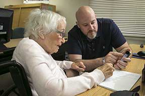 Instructor helping member with cell phone